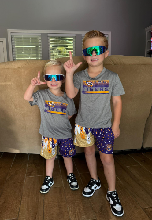 Two young brothers in LSU Tigers tees and Parish Culture ice cream shorts
