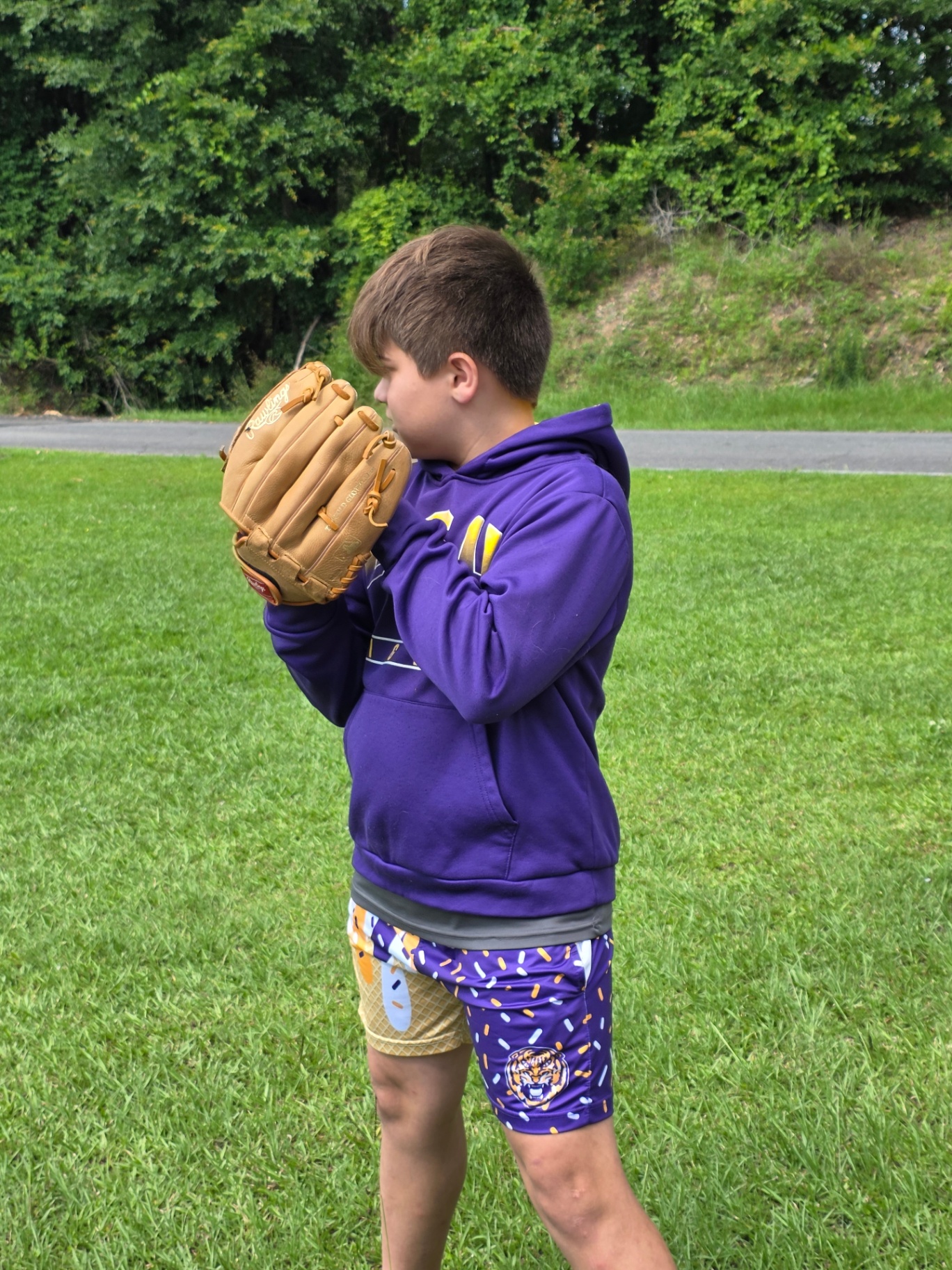 Boy in LSU hoodie and Tigers sprinkle shorts with baseball glove